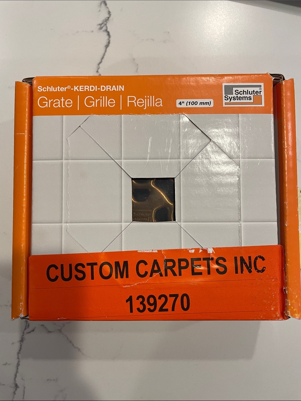 Schluter Grate Drain Cover in vintage gold color